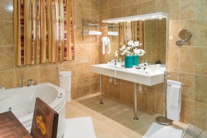 A bathroom almost as big as the room, with big TV inside !